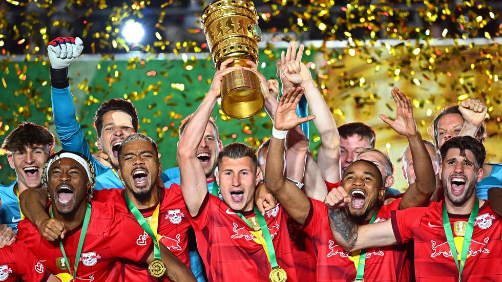 Leipzigs Willi Orban hält die Siegertrophäe in die Höhe und bejubelt mit seinen Teamgefährten den zweiten Pokalsieg in der Vereinsgeschichte. (Archivbild) Leipzigs Willi Orban hält die Siegertrophäe in die Höhe und bejubelt mit seinen Teamgefährten den zweiten Pokalsieg in der Vereinsgeschichte. (Archivbild)