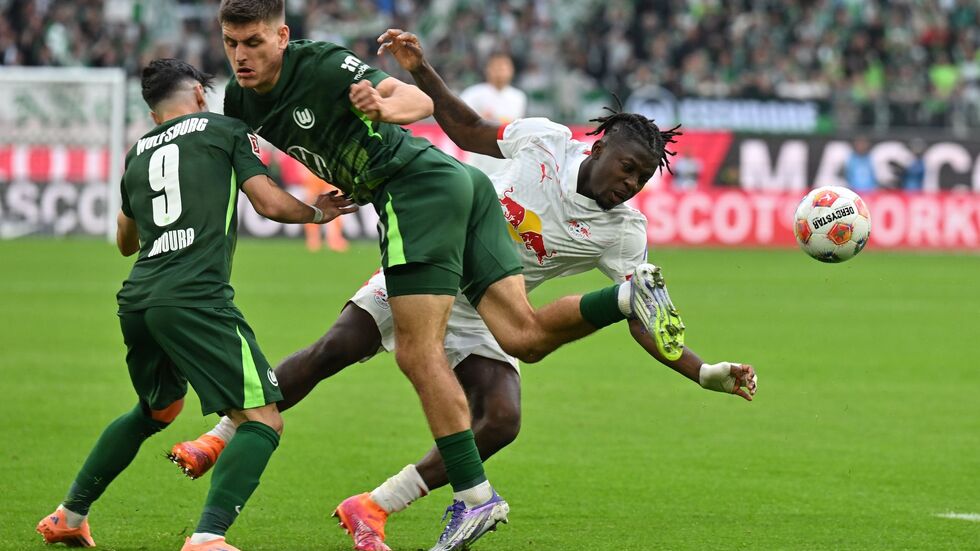 Kaum zu stoppen: Leipzigs Torschütze Johan Bakayoko (r) wird von den Wolfsburgern Joakim Maehle und Mohammed Amoura bedrängt.