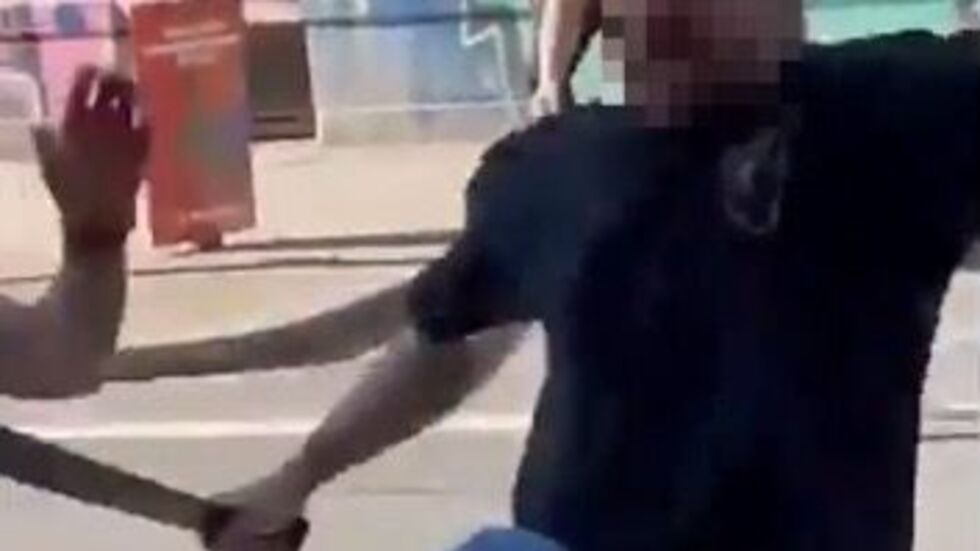 Einer der Männer schlägt mit der stumpfen Seite einer Machete auf seinen am Boden liegenden Kontrahenten ein.