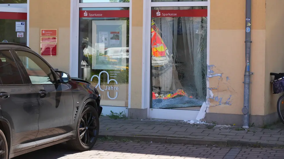 Der beschädigte BMW X3 vor der kaputten Außenscheibe der Bankfiliale.