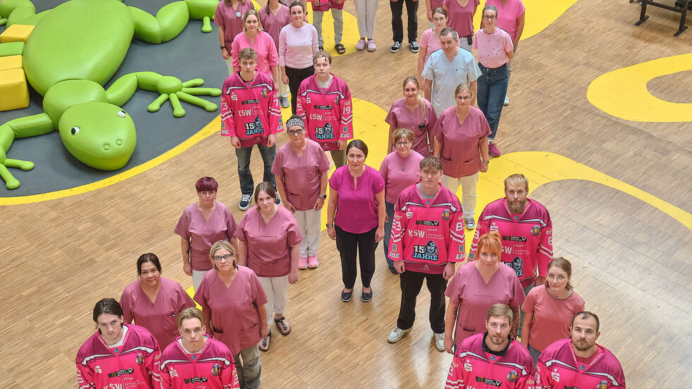 Eishockeyprofis aus dem IceFighters-Team mit Mitarbeitern des Brustzentrums der Universitätsklinik Leipzig im Gebäude der Uni-Kinderklinik.