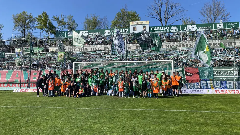 Die Mannschaft mit den Kinder-Helfern und den Fans der BSG Chemie Leipzig.