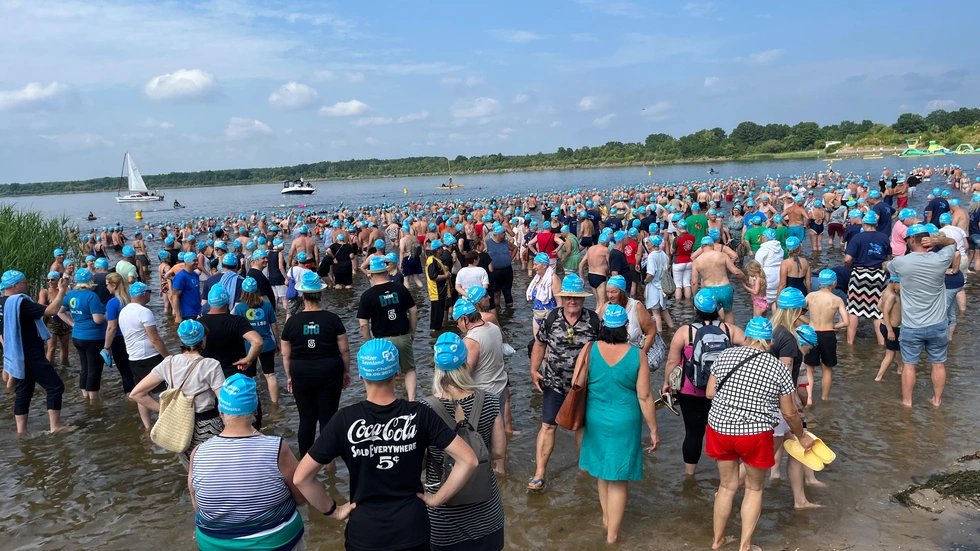 Über 5.000 Menschen mit blauen Badekappen liefen in die fünf Seen und begrüßten so den Seenverbund.