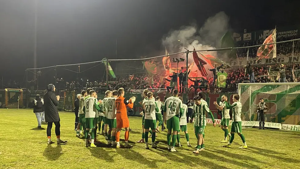 Die Mannschaft der BSG Chemie Leipzig lässt sich nach ihrem Heimsieg vor dem Fanblock feiern.