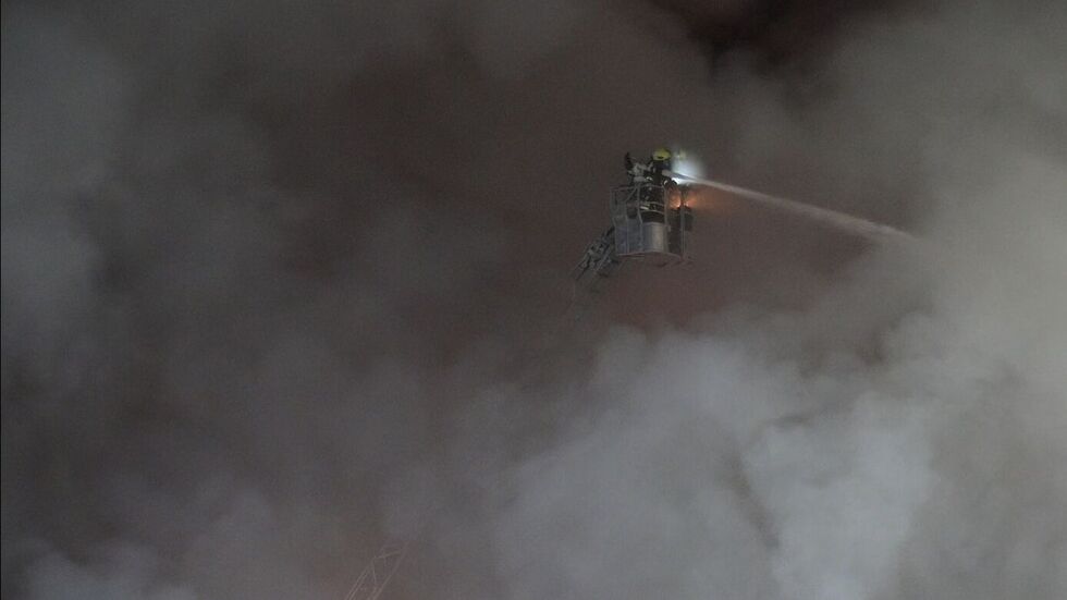 Ein fast schon episches Foto: Feuerwehrleute auf der Drehleiter inmitten einer Rauchwolke beim Kampf gegen die Flammen.