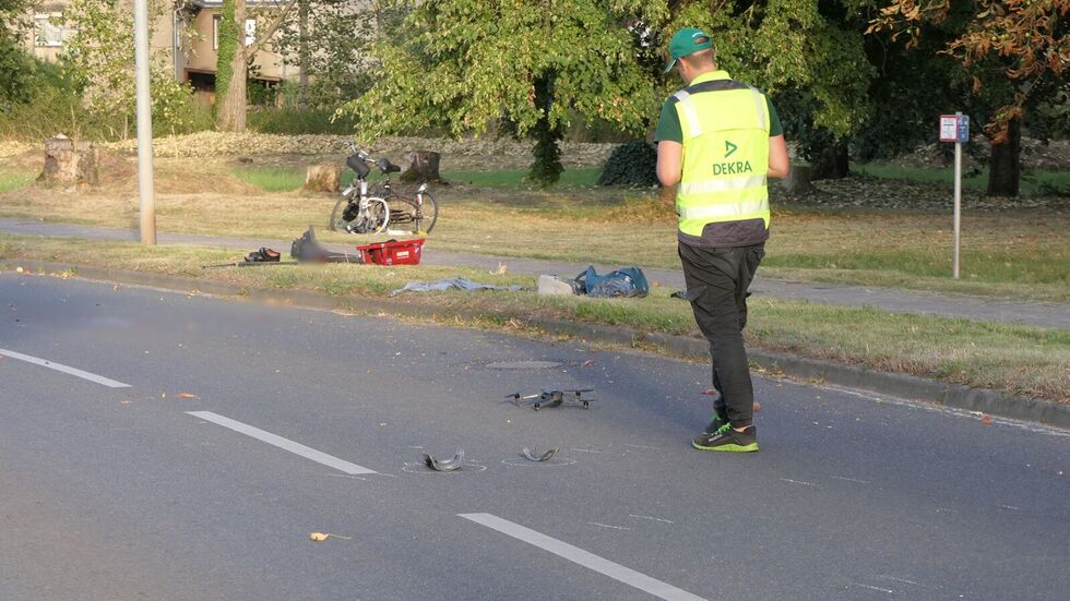 Ein Polizist dokumentiert Trümmerteile auf der Straße.
