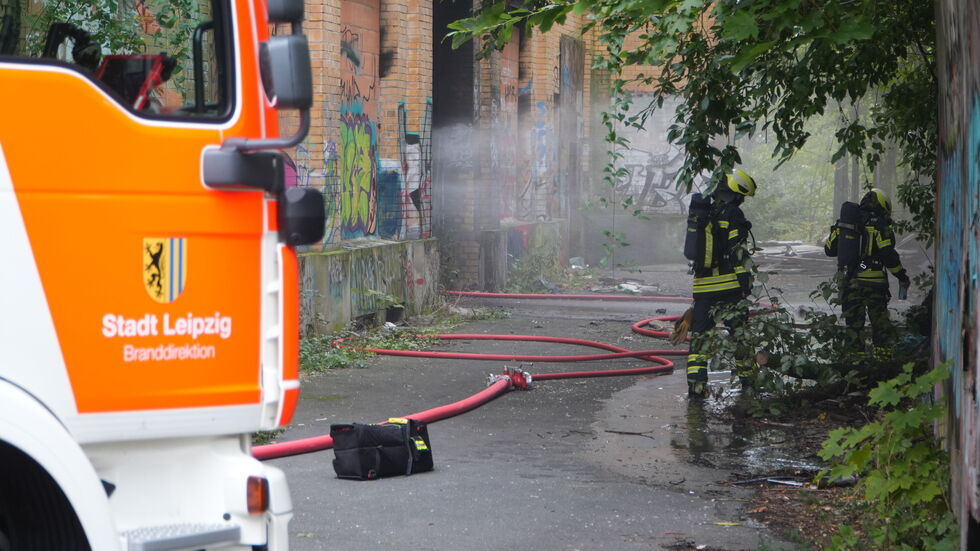 Feuerwehrleute beim Löschen der qualmenden Fabrik.
