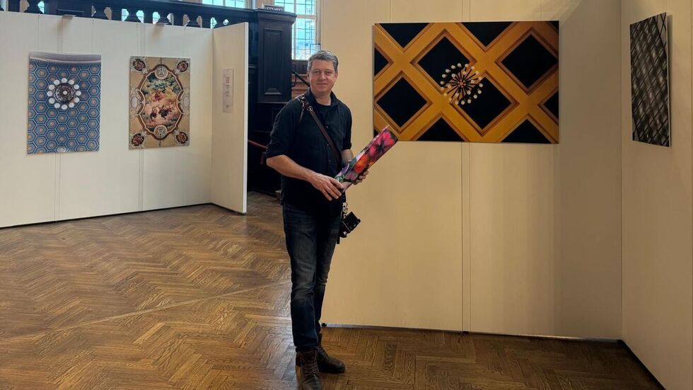 Künstler Daniel Reiche vor einigen seiner besonderen Fotografien.